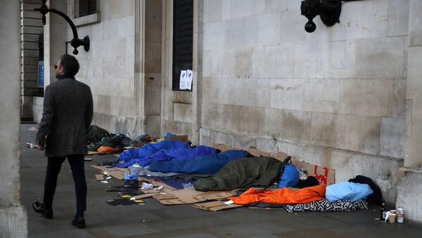 A man walks past homeless people sleeping rough in London - Sputnik International