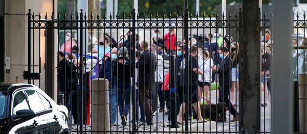 A crowd of members of the public gathers outside the gates of Walter Reed National Military Medical Center as the Marine One helicopter with U.S. President Donald Trump aboard  - Sputnik International
