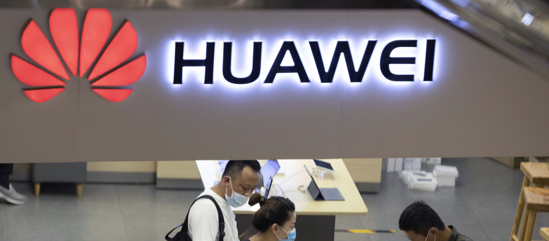 In this July 15, 2020, file photo, visitors wearing masks to curb the spread of the coronavirus look at the latest products at a Huawei store in Beijing. China accused Washington of damaging global trade with sanctions that threaten to cripple tech giant Huawei and said Tuesday it will protect Chinese companies but gave no indication of possible retaliation - Sputnik International, 1920, 23.10.2020