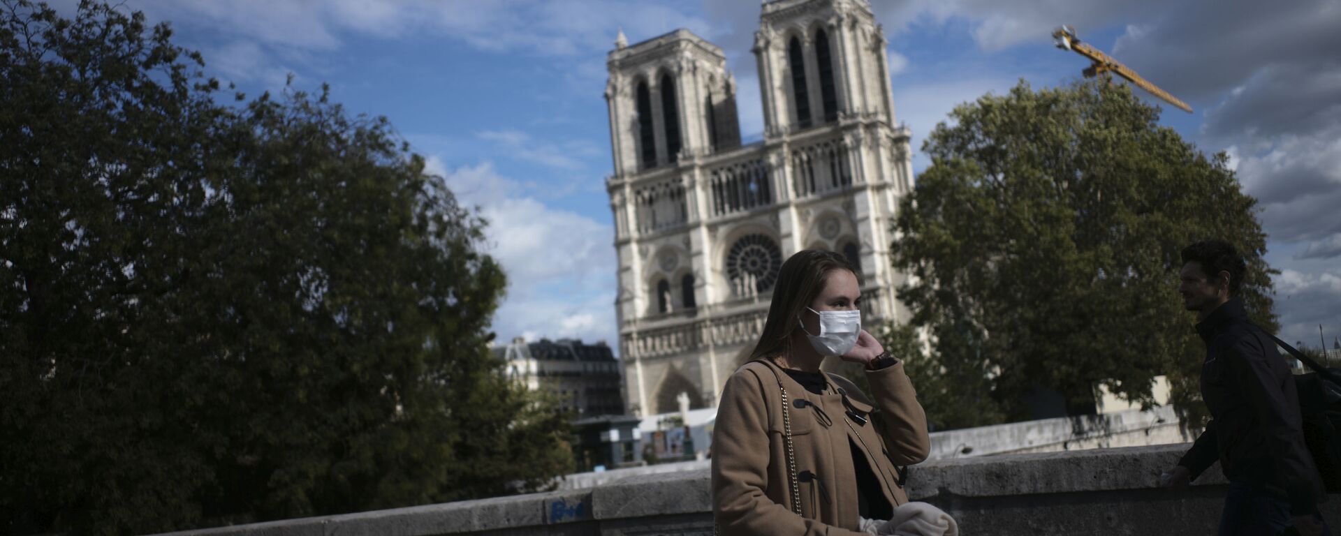 A woman walks by Notre Dame cathedral Saturday Sept.26, 2020 in Paris. While France suffered testing shortages early in the pandemic, ramped-up testing since this summer has helped authorities track a rising tide of infections across the country. - Sputnik International, 1920, 18.09.2021