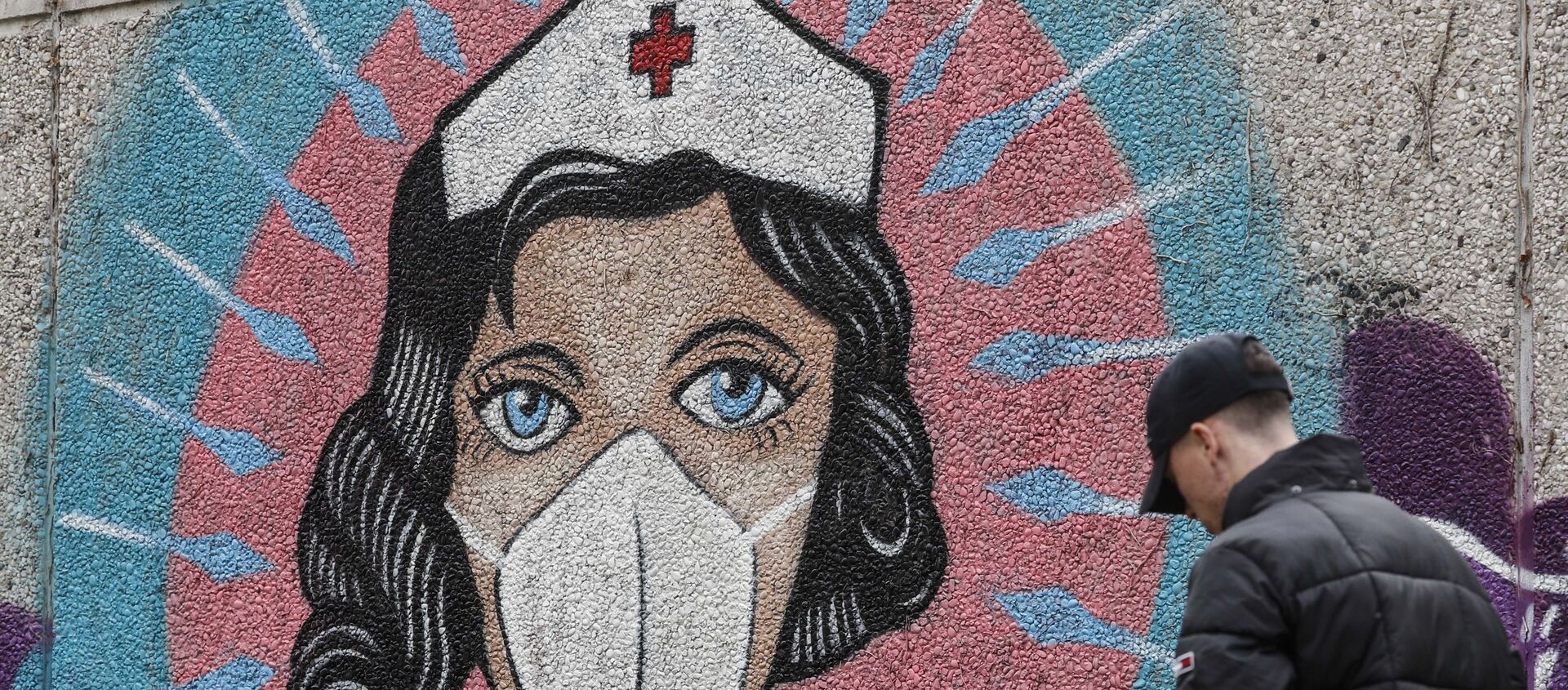 A man passes a graffiti by street artist 'Uzey', depicting a nurse as a superhero amid the coronavirus pandemic on a wall in Hamm, Germany, 28 September 2020. - Sputnik International, 1920, 28.03.2021