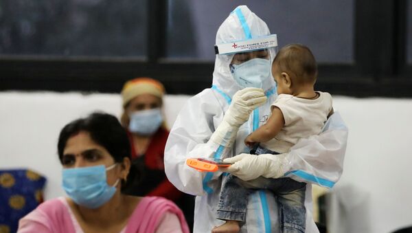 A medical worker in personal protective equipment (PPE) plays with a child of woman recovering inside a quarantine centre for the coronavirus disease (COVID-19) patients amidst the spread of the disease at an indoor sports complex in New Delhi, India, September 22, 2020 - Sputnik International