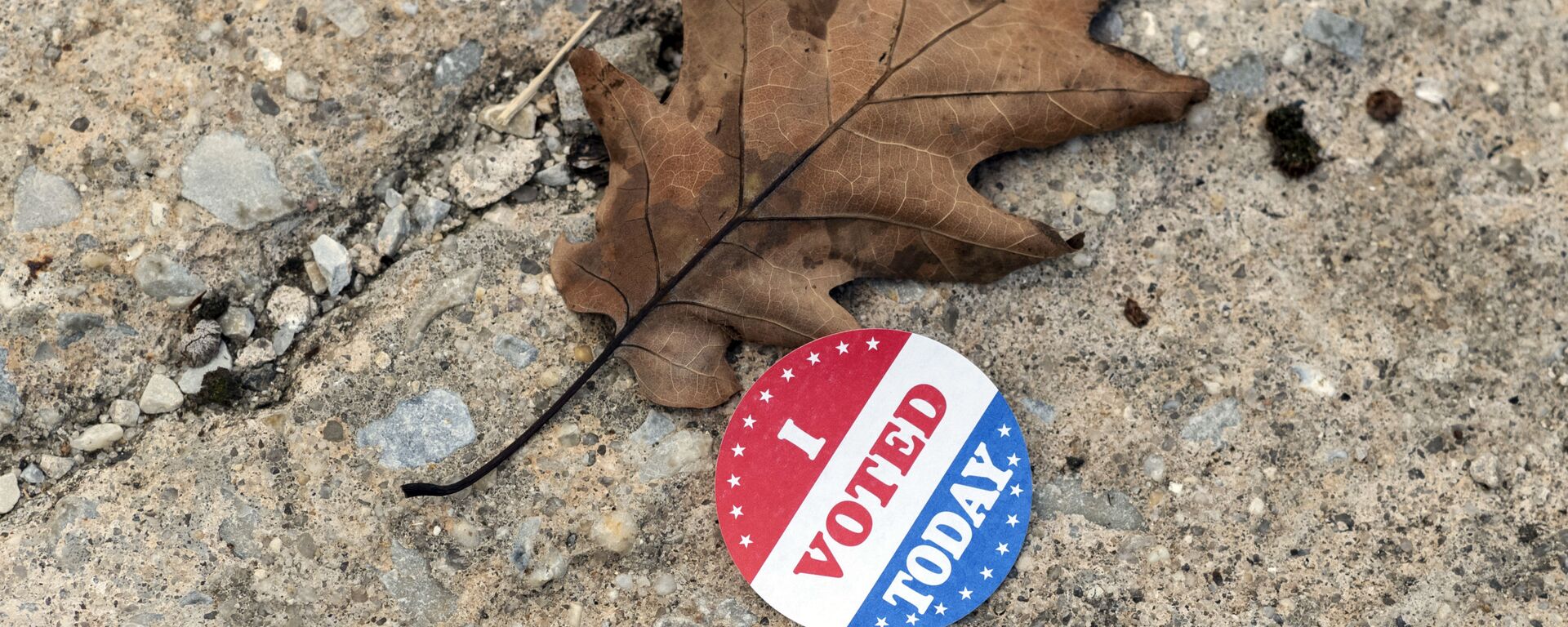 A discarded voting sticker lies on the ground at a satellite election office at Overbrook High School on Thursday, Oct. 1, 2020, in Philadelphia. The city of Philadelphia has opened several satellite election offices and more are slated to open in the coming weeks where voters can drop off their mail in ballots before Election Day.  - Sputnik International, 1920, 15.02.2023