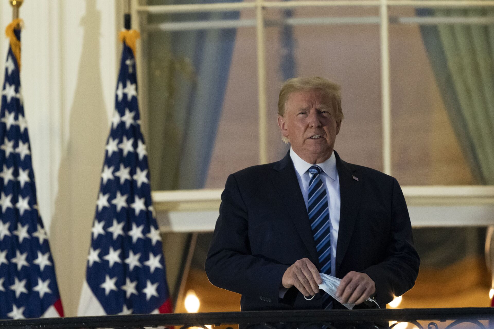 President Donald Trump removes his mask as he stands on the Blue Room Balcony upon returning to the White House Monday, Oct. 5, 2020, in Washington, after leaving Walter Reed National Military Medical Center, in Bethesda, Md. Trump announced he tested positive for COVID-19 on Oct. 2 - Sputnik International, 1920, 02.12.2021