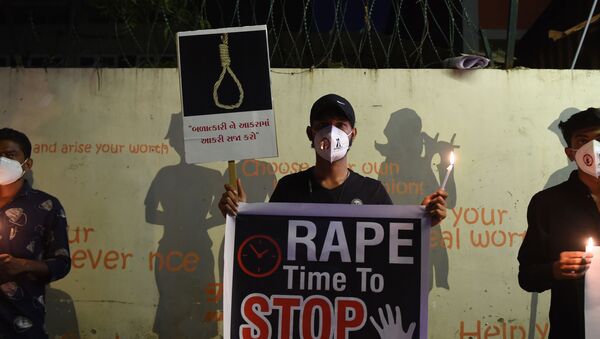 Protesters display placards to condemn the alleged gang-rape and murder of a low-caste teenaged woman in Uttar Pradesh state during a candlelight vigil in Ahmedabad on October 6, 2020.  - Sputnik International
