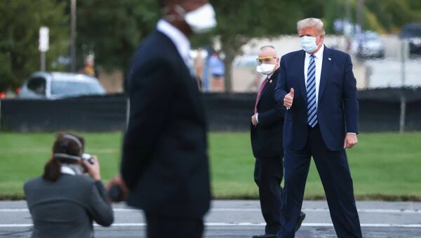 U.S. President Donald Trump gives a thumbs up to a White House staff photographer as he stands on the helipad of Walter Reed National Military Medical Center while preparing to board the Marine One helicopter to fly back to the White House in Washington after a fourth day of treatment for the coronavirus disease (COVID-19) at the hospital in Bethesda, Maryland, U.S., October 5, 2020. REUTERS/Jonathan Ernst - Sputnik International