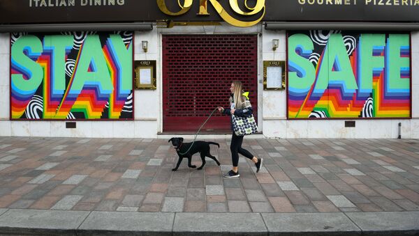 A pedestrian walks past a shuttered restaurant with a mural that reads Stay Safe on it in Glasgow on May 16, 2020, during the novel coronavirus COVID-19 pandemic lockdown - Sputnik International