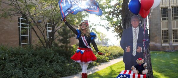 U.S. President Donald Trump's supporter Lady MAGA USA walks waving a flag outside the site of the 2020 vice presidential debate between U.S. Vice President Mike Pence and Democratic vice presidential nominee and U.S. Senator Kamala Harris, at the campus of the University of Utah in Salt Lake City, Utah, U.S., October 7, 2020 - Sputnik International