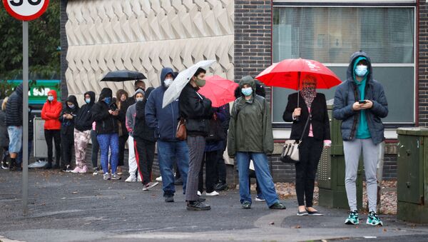 People stand in a queue to get tested for COVID-19 at a walk-through centre amid the coronavirus disease (COVID-19) outbreak in Liverpool Britain, October 6, 2020. - Sputnik International