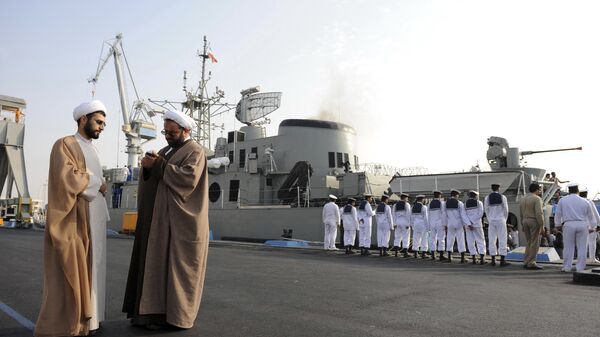In this Feb. 21, 2010 photo, two clerics stand at left as Iran's Jamaran guided-missile destroyer and navy members prepare for an exercise in the Persian Gulf, along the coast of Iran.  - Sputnik International