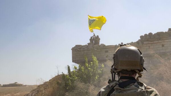 In this Sept. 21, 2019, photo, released by the U.S. Army, a U.S. soldier oversees members of the Syrian Democratic Forces as they demolish a Kurdish fighters' fortification and raise a Tal Abyad Military Council flag over the outpost as part of the so-called safe zone near the Turkish border. - Sputnik International