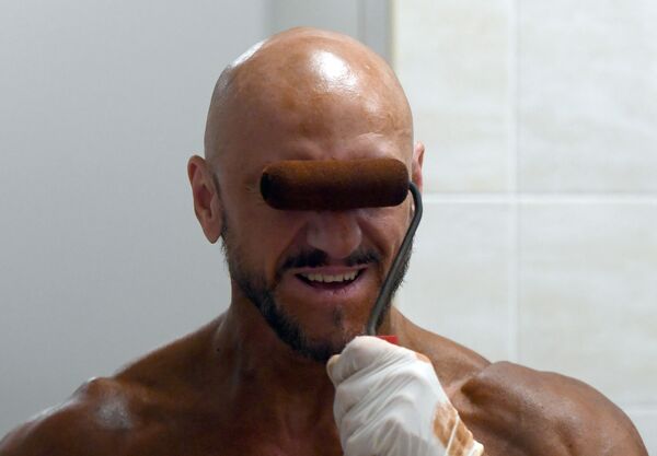 A bodybuilder is getting tanned as he prepares for a competition in Kazan - Sputnik International