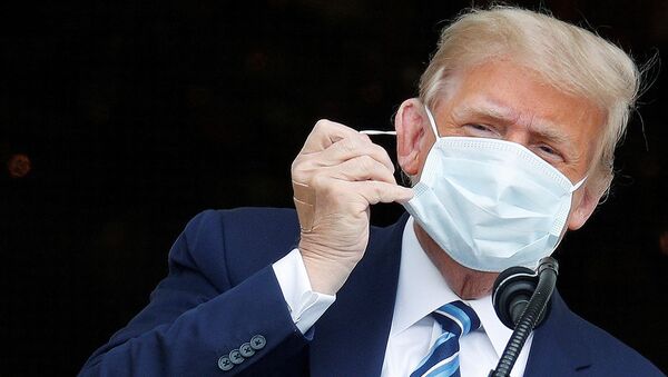 U.S. President Donald Trump, with bandages seen on his hand, takes off his face mask as he comes out on a White House balcony to speak to supporters gathered on the South Lawn for a campaign rally that the White House is calling a peaceful protest in Washington, U.S., October 10, 2020. - Sputnik International