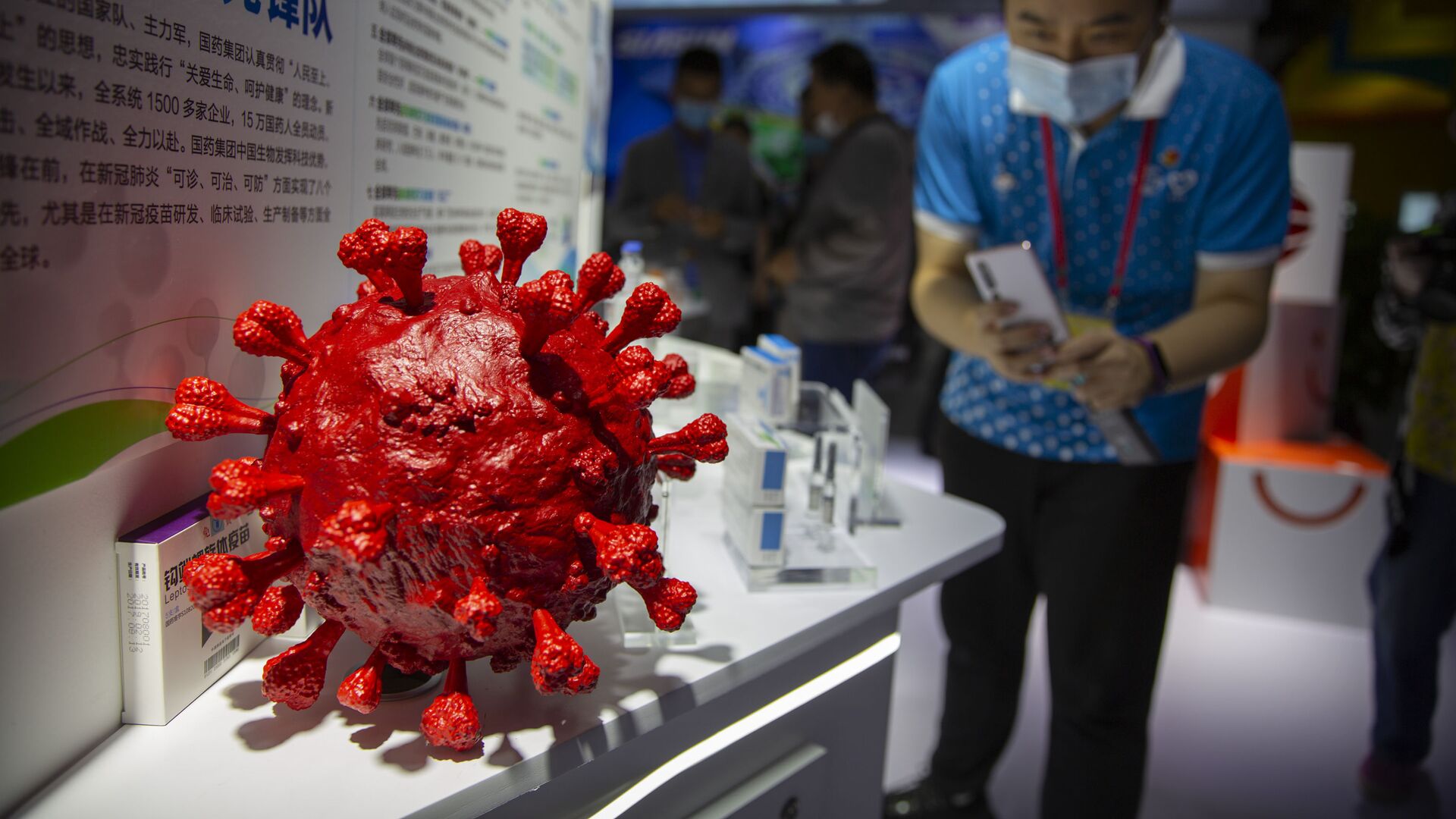 A visitor wearing a face mask takes a photo of a model of a coronavirus and boxes for COVID-19 vaccines at a display by Chinese pharmaceutical firm Sinopharm at the China International Fair for Trade in Services (CIFTIS) in Beijing, Saturday, Sept. 5, 2020. With the COVID-19 pandemic largely under control, China's capital on Saturday kicked off one of the first large-scale public events since the start of the coronavirus outbreak, as tens of thousands of attendees were expected to visit displays from nearly 2,000 Chinese and foreign companies showcasing their products and services. - Sputnik International, 1920, 06.09.2021