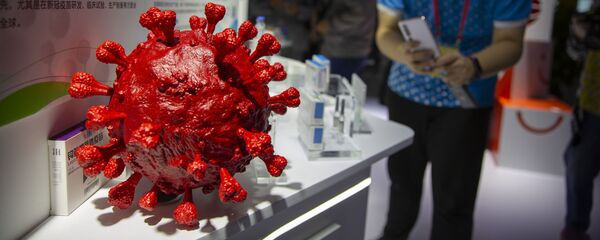 A visitor wearing a face mask takes a photo of a model of a coronavirus and boxes for COVID-19 vaccines at a display by Chinese pharmaceutical firm Sinopharm at the China International Fair for Trade in Services (CIFTIS) in Beijing, Saturday, Sept. 5, 2020. With the COVID-19 pandemic largely under control, China's capital on Saturday kicked off one of the first large-scale public events since the start of the coronavirus outbreak, as tens of thousands of attendees were expected to visit displays from nearly 2,000 Chinese and foreign companies showcasing their products and services. - Sputnik International