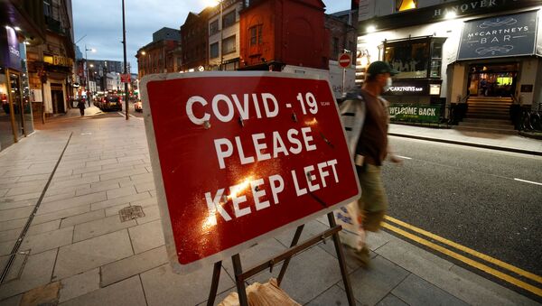 A man walks past a signage in Liverpool City Centre as Merseyside remains under lockdown due to the coronavirus disease (COVID-19) outbreak, in Liverpool, Britain September 22, 2020 - Sputnik International