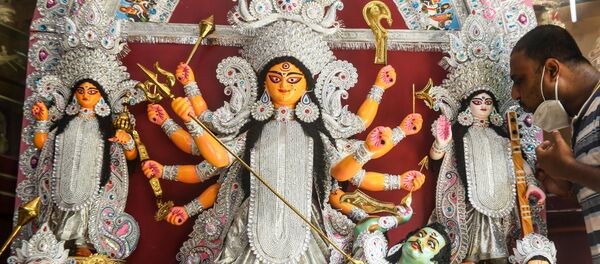 Craftsman Kaushik Ghosh gives finishing touches to a fiberglass idol of Hindu Goddess Durga before sending to the USA where it will be used for the Durga Puja festival, inside his workshop in Kolkata on June 4, 2020. Craftsman Kaushik Ghosh gives finishing touches to a fiberglass idol of Hindu Goddess Durga before sending to the USA where it will be used for the Durga Puja festival, inside his workshop in Kolkata on June 4, 2020. - Sputnik International