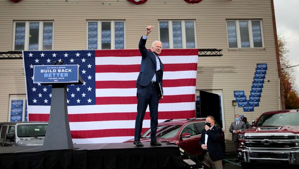 Democratic presidential candidate Joe Biden raises his arm  during a drive-in campaign event in Toledo, Ohio, U.S., October 12, 2020. - Sputnik International
