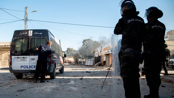 Tunisian security forces stand guard as protesters take to the streets of the impoverished Tunisian town of Sbeitla on October 13, 2020 after a man died when authorities demolished an illegal kiosk where he was sleeping. - Sputnik International