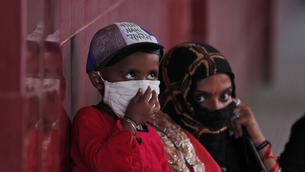 A woman and a child wait to give their nasal swab samples to test for COVID-19 at a government hospital in Unchahar, Raebareli district, Uttar Pradesh, India, Monday, Sept. 28, 2020. - Sputnik International
