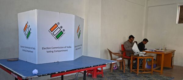 Election officials sit inside an empty polling station during the fifth phase of India's general elections in Kashmir's Shopian district, south of Srinagar, on May 6, 2019 - Sputnik International