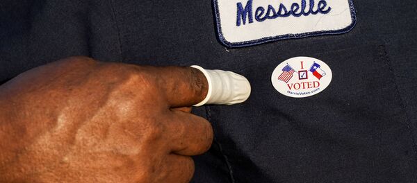 A person wearing a finger sack points at an I Voted sticker after casting ballot for the upcoming presidential election as early voting begins in Houston, Texas, U.S., October 13, 2020. - Sputnik International