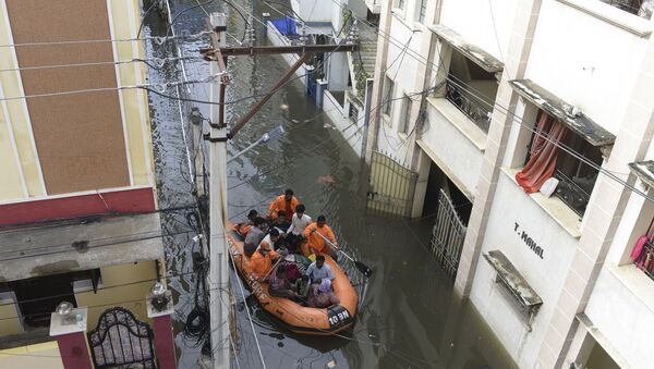 National Disaster Response Force (NDRF) personnel evacuate local residents in a boat along a flooded street following heavy rains in Hyderabad on October 15, 2020. - Sputnik International