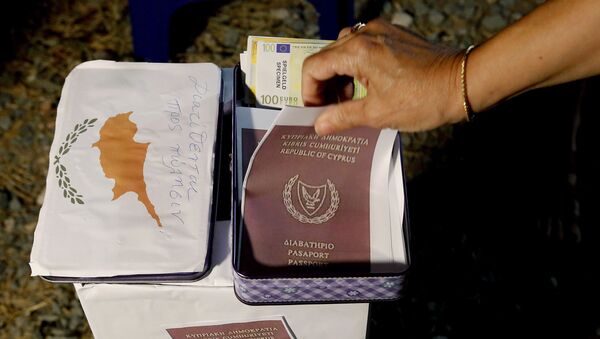 A demonstrator takes a  mock copy of Cyprus passport during a demonstration against corruption outside of the conference center in the capital Nicosia, Cyprus, Wednesday, Oct. 14, 2020.  - Sputnik International