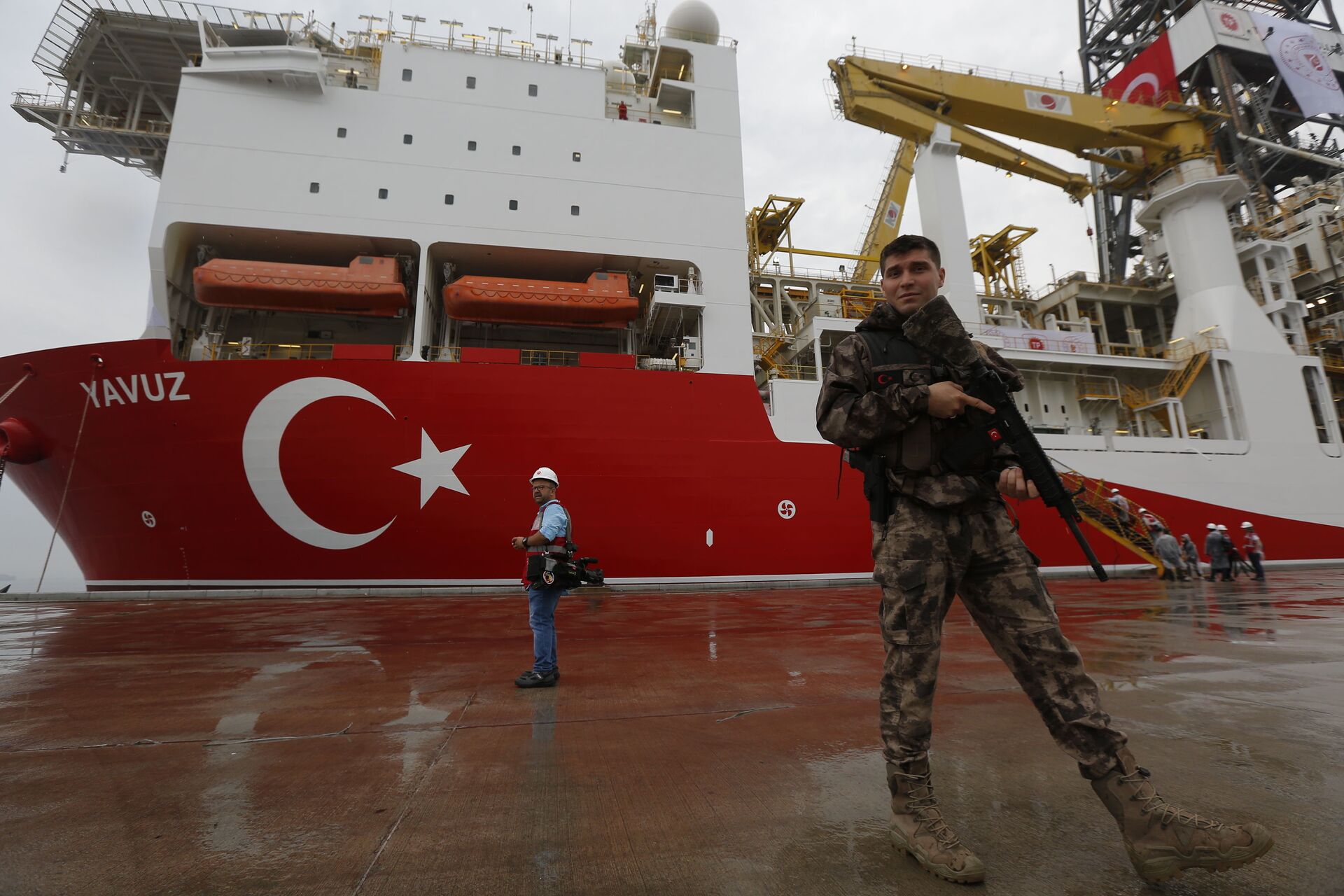 FILE - In this Thursday, June 20, 2019 file photo, a Turkish police officer patrols the dock, backdropped by the drilling ship 'Yavuz' scheduled to be dispatched to the Mediterranean, at the port of Dilovasi, outside Istanbul - Sputnik International, 1920, 07.09.2021