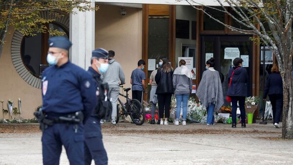 People bring flowers to the Bois d'Aulne college after the attack in the Paris suburb of Conflans St Honorine, France, October 17, 2020. REUTERS/Charles Platiau - Sputnik International