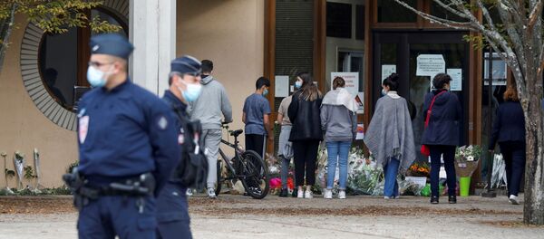People bring flowers to the Bois d'Aulne college after the attack in the Paris suburb of Conflans St Honorine, France, October 17, 2020. REUTERS/Charles Platiau - Sputnik International