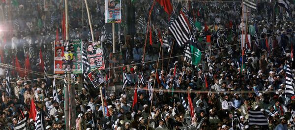 Supporters of Pakistan Democratic Movement (PDM), an alliance of political opposition parties, wave flags as they listen to their leaders during an anti-government protest rally in Karachi, Pakistan October 18, 2020 - Sputnik International