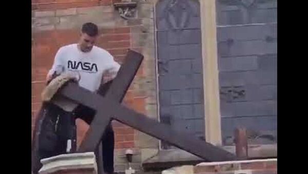 A man tears down a church cross - Sputnik International