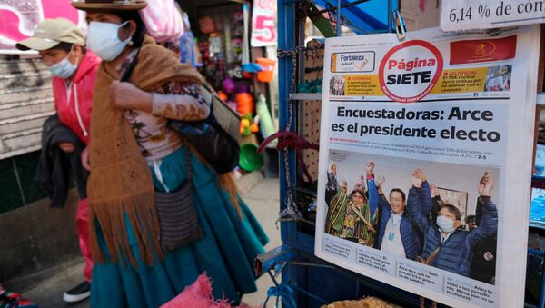 Women walk past a newspaper stand and a headline reading Pollsters: Arce is the president-elect  , in La Paz, Bolivia October 19, 2020.  - Sputnik International