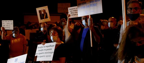 Demonstrators with placards reading in Greek , second right, Cyprus I die for you, they are all a lie and on the left, Open the windows open the minds we are not complicit we are not lambs during a demonstration against corruption outside of the conference center in the capital Nicosia, Cyprus, Wednesday, Oct. 14, 2020.  - Sputnik International