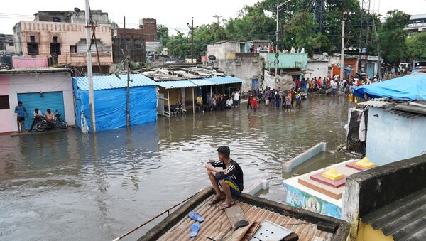 People are seen in a flooded residential area after heavy rainfall in Hyderabad - Sputnik International