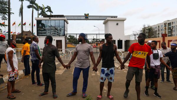 Demonstrators hold hands as they gather near the Lagos State House, despite a round-the-clock curfew imposed by the authorities on the Nigerian state of Lagos in response to protests against alleged police brutality, Nigeria October 20, 2020.  - Sputnik International