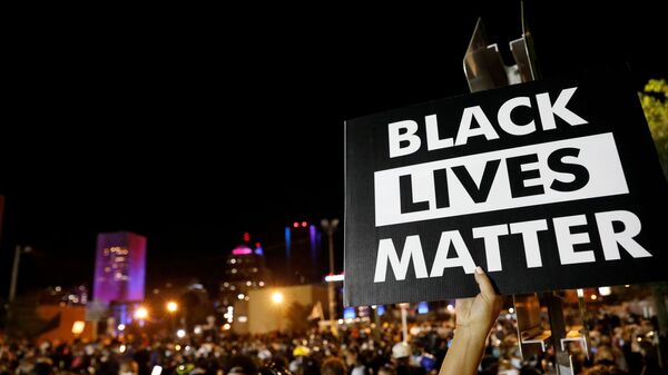 A demonstrator holds up a Black Lives Matter sign during a protest over the death of a black man, Daniel Prude, after police put a spit hood over his head during an arrest on 23 March in Rochester, New York, US 6 September 2020. - Sputnik International