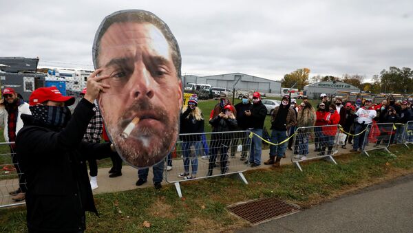 A supporter of US President Donald Trump holds up a photo of Hunter Biden for fellow supporters as they wait in line to attend Trump's campaign event at Erie International Airport in Erie, Pennsylvania, US, 20 October 2020. - Sputnik International