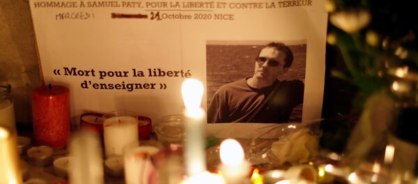 Candles are lit at a makeshift memorial as people gather to pay homage to Samuel Paty, the French teacher who was beheaded on the streets of the Paris suburb of Conflans-Sainte-Honorine, as part of a national tribute, in Nice, France, October 21, 2020 - Sputnik International
