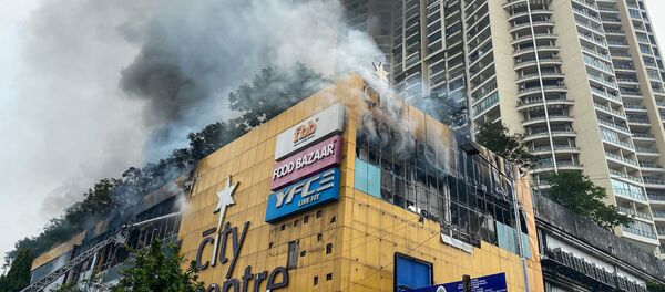 Firefighters (L) douse a fire at a City Centre shopping mall in Mumbai on October 23, 2020 - Sputnik International