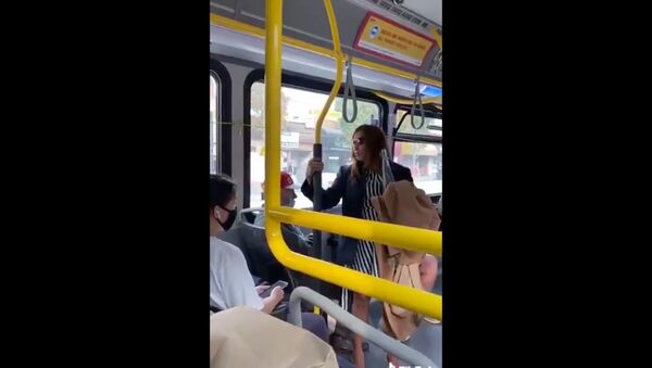 Cellphone footage captures moment a TransitLink commuter is pushed out of a stationary bus moments after spitting on a fellow traveler. The incident is being investigated by Canada's Metro Vancouver Transit Police. - Sputnik International