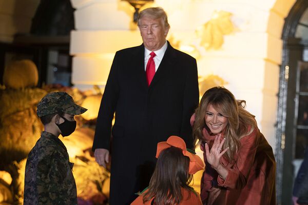 President Donald Trump and first lady Melania Trump greet guests on the south lawn on 25 October 2020. To ensure the health and safety of guests and staff during the festivities, extra measures such as facemasks, social distancing, and hand-sanitiser were introduced.   - Sputnik International