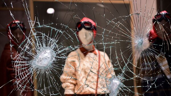 A damaged window of a store is seen as people protest against the new restrictions introduced by the government to curb the coronavirus disease (COVID-19) infections, in Turin, Italy, October 26, 2020. - Sputnik International