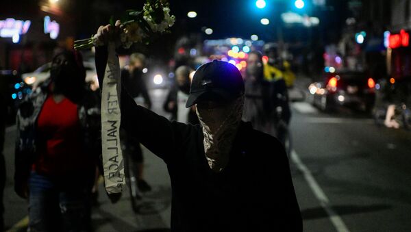 A demonstrator holds a bouquet of flowers during a rally after the death of Walter Wallace Jr., a Black man who was shot by police in Philadelphia, Pennsylvania, U.S., October 27, 2020. - Sputnik International