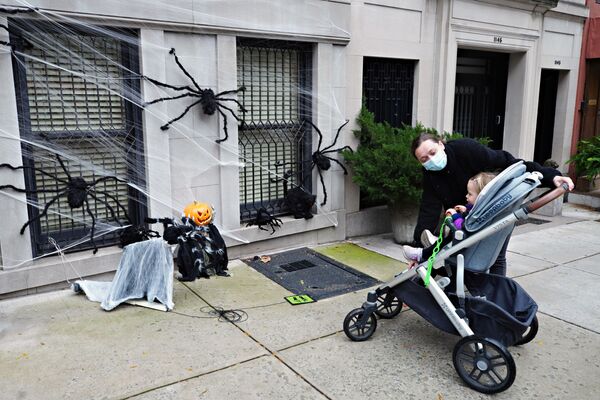 A woman shows Halloween decorations to a child, New York City, 28 October 2020. - Sputnik International