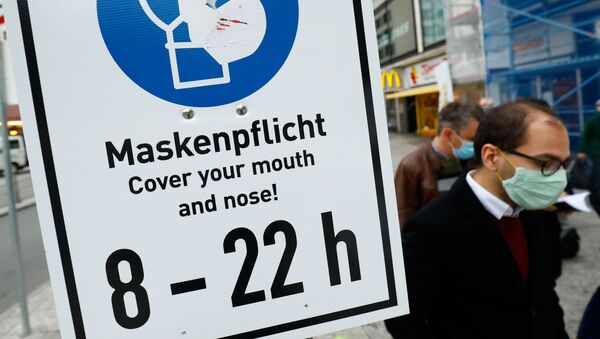 Pedestrians walk along a sign that reminds to wear a face mask as the coronavirus disease (COVID-19) outbreak continues in Frankfurt, Germany October 29, 2020. - Sputnik International