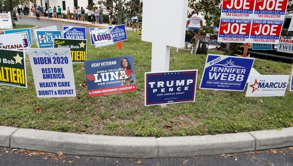 Campaign signs are posted near the Supervisor of Elections Office polling station while people line up for early voting in Pinellas County ahead of the election in Largo, Florida. U.S. October 21, 2020. - Sputnik International