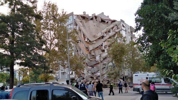 Locals look at a damaged building after a strong earthquake struck the Aegean Sea on Friday and was felt in both Greece and Turkey, where some buildings collapsed in the coastal province of Izmir, Turkey, October 30, 2020 - Sputnik International