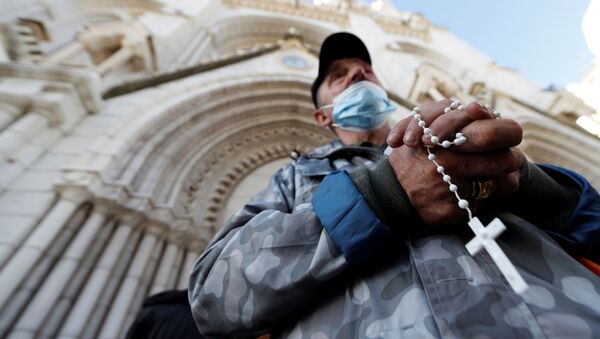 A man prays in front of the Notre Dame church to pay tribute to the victims of a deadly knife attack in Nice, France, October 30, 2020 - Sputnik International